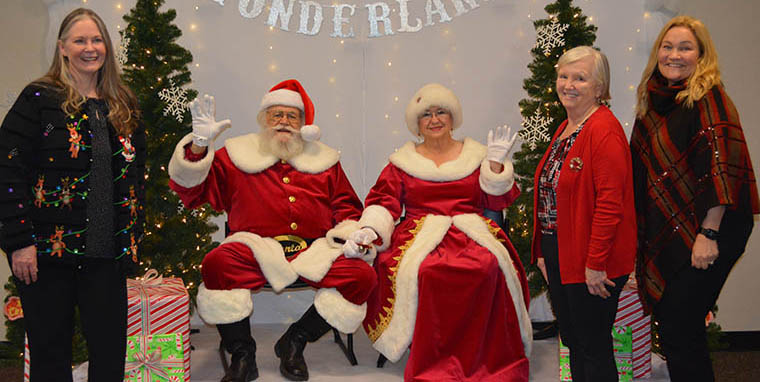 People with Santa and Mrs. Claus